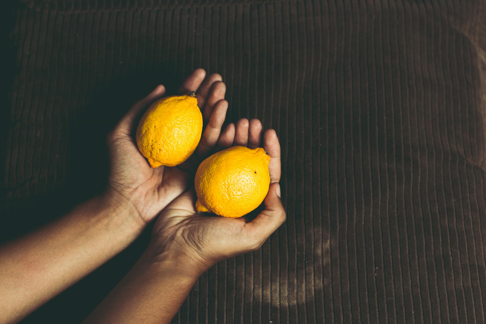 Bright yellow lemons arranged on a pastel green background