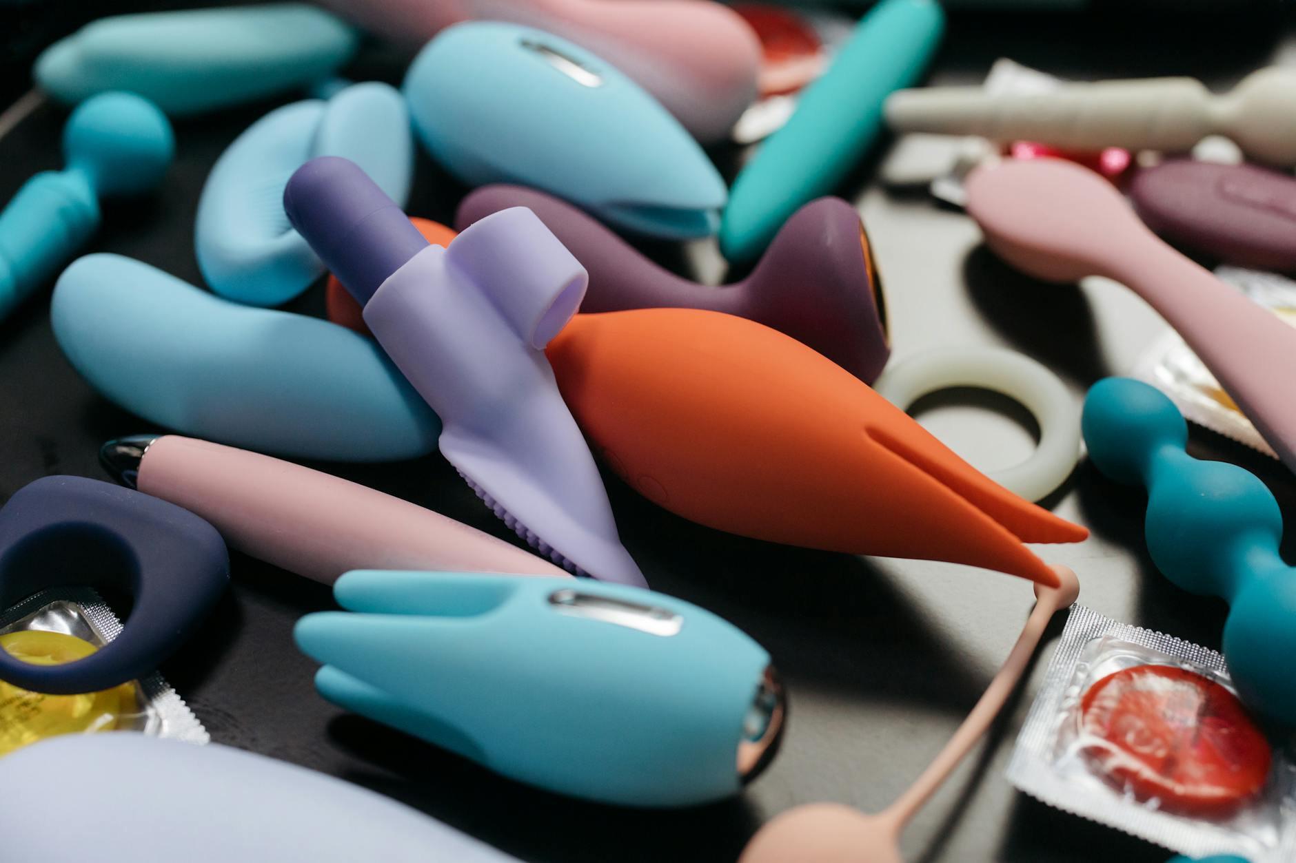 Two vibrators held against a purple background representing clitoral stimulation tools